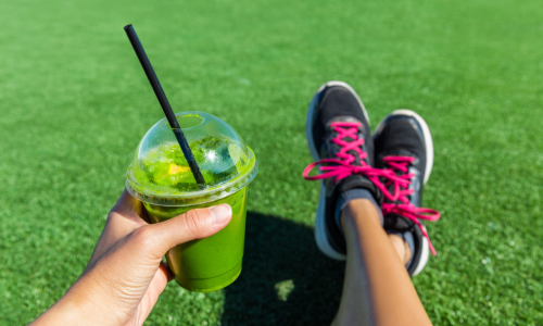 Best Protein Shakes in Chapel Hill | Person holding a shake, sitting in the grass